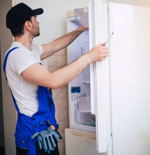 professional-young-repairman-worker-uniform-cap-with-modern-toolbox-with-equipment-is-repairing-refrigerator-kitchen_283617-2767